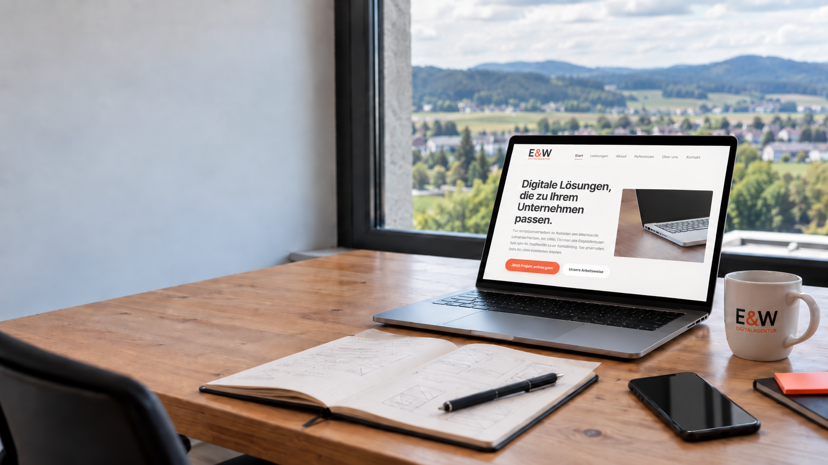 Arbeitsplatz mit Laptop, der die Website der E&W Digitalagentur zeigt